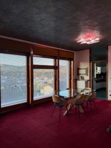 a dining room with a table and chairs and windows at Al Bricco dei Frati in Dogliani