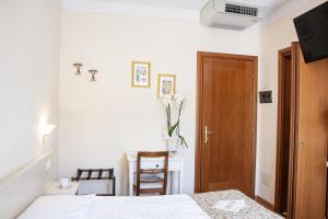 a bedroom with a bed and a wooden door at Hotel Belvedere in Torri del Benaco