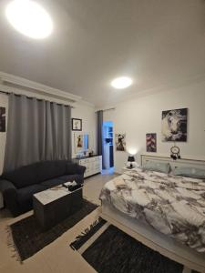 a large bedroom with a bed and a couch at Studio towam hospital 2 in Al Ain +2 photos