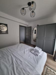 a white bed in a bedroom with two lights at ApuLux Apartments in Alba Iulia