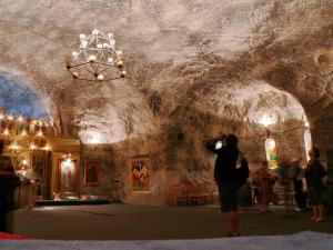 a woman taking a picture of a room in a cave at Vila Cristal in Târgu Ocna +21 photos