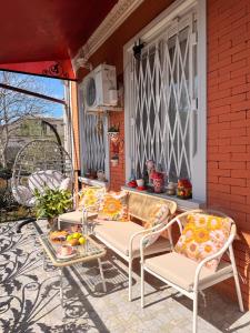 a porch with chairs and a table with fruit on it at Sunny Flower in Kutaisi