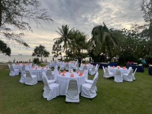 a group of white tables and chairs on the grass at The Princess Beachfront Resort in Ban Tha Fat +171 photos