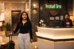a woman with a suitcase in front of a hotelnir at Hotel k11 in Solan