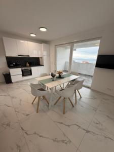 a kitchen and dining room with a table and chairs at Astrid Deluxe in Novalja
