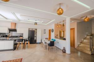 a kitchen and living room with a table and chairs at Villa moderne à 5 min de la plage avec jardin et 3 salons in Essaouira