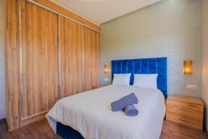 a bedroom with a large bed with a blue headboard at Villa moderne à 5 min de la plage avec jardin et 3 salons in Essaouira