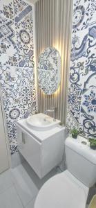 a bathroom with a sink and a toilet and a mirror at The Crib at Royal Oceancrest Mactan in Lapu Lapu City