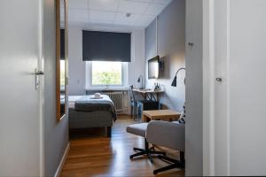 ein Zimmer mit einem Bett, einem Schreibtisch und einem Fenster in der Unterkunft Port Hotel in Karlshamn + 20 Fotos