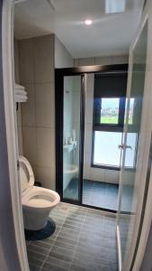 a bathroom with a toilet and a walk in shower at MM No6 Villa in Luodong +3 photos