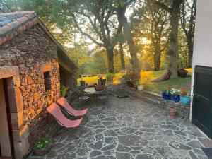 a patio with chairs and a table and trees at Les chambres de La Serre in Camarès