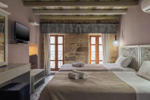 a bedroom with a large bed with towels on it at Vetus Oppidum Boutique Guesthouse in Chania