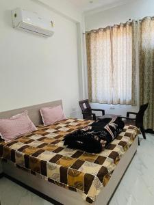 a bedroom with a bed with a checkered bedspread at Hotel Devansh , Niwai in Palāi