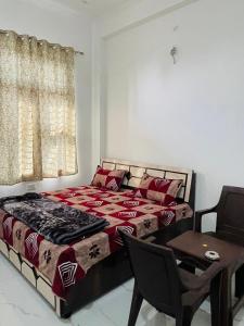 a bedroom with a bed and a table and a chair at Hotel Devansh , Niwai in Palāi