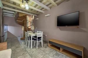 a dining room with a table and a tv on a wall at Vetus Oppidum Boutique Guesthouse in Chania