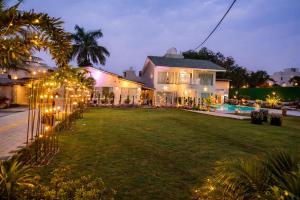 a house with lights in a yard at night at Amber Resort & Spa in Indore