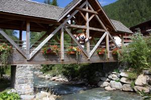 Ein Hund steht auf einer Brücke über einem Fluss in der Unterkunft Dormio Resort Les Portes du Mont Blanc in Vallorcine