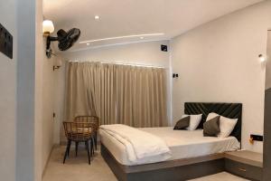 a bedroom with a bed and a chair in it at Amber Resort & Spa in Indore