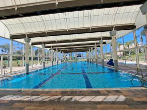 a large swimming pool with blue water at The Caesar Stay in Caesarea