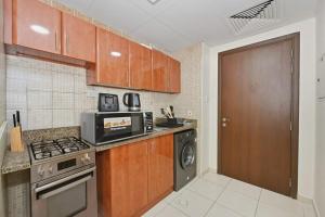 a kitchen with a stove and a microwave at Bloomfields Studio Emirates Cluster 24 Intl. City in Dubai +3 photos
