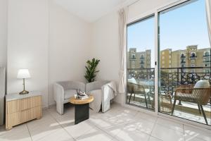 a living room with a couch and a balcony at Bloomfields Studio Emirates Cluster 24 Intl. City in Dubai