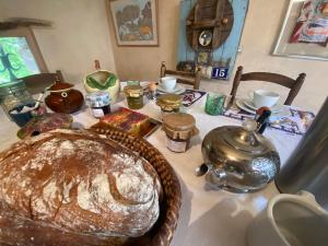 a table with a cake and a tea kettle on it at Les chambres de La Serre in Camarès