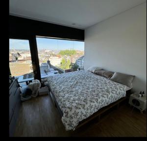 a bedroom with a bed and a large window at Room with an amazing city view in Basel
