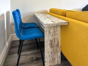 Ein Holztisch mit einem blauen Stuhl neben einem Sofa in der Unterkunft Dingleton 45 in Melrose