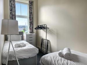 ein Schlafzimmer mit zwei Einzelbetten und einem Fenster in der Unterkunft Dingleton 45 in Melrose