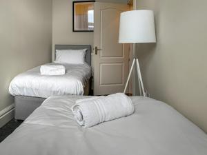 ein Zimmer mit zwei Betten und einer Lampe und ein Zimmer mit zwei Betten in der Unterkunft Dingleton 45 in Melrose + 2 Fotos