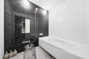 a bathroom with a tub and a sink and a mirror at Nord Birch in Tōbetsu