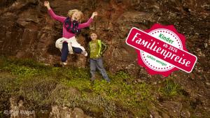 a girl and a boy are jumping on a rock at Haus Alleegarten in Bad Bertrich