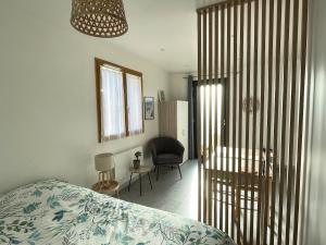 a bedroom with a bed and a desk and a chair at Studio au calme - rez de jardin in Chignin