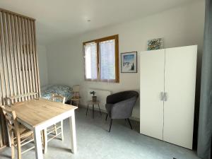 a room with a table and a chair and a bedroom at Studio au calme - rez de jardin in Chignin +11 photos