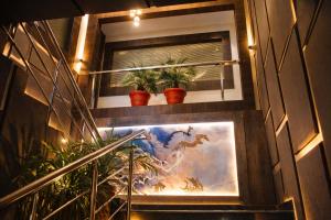 two potted plants sitting on a window ledge with a painting at Hotel k11 in Solan