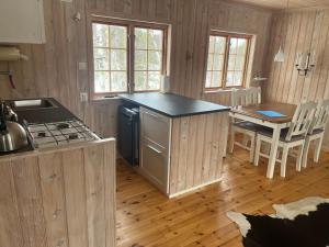 a kitchen with a stove and a table with chairs at Cabin in Tydal, enjoy! in Tydal