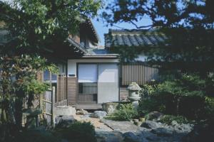 a house with a gate and a stone yard at KAZENO Kurayoshi in Kurayoshi
