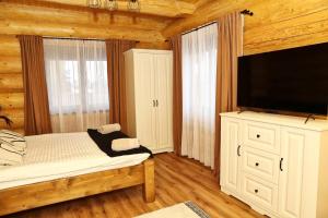 a bedroom with a bed and a flat screen tv at Chalet Marilyn in Topliţa