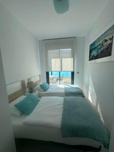 two beds in a bedroom with a view of the ocean at Prestige Sunny Terrace Apartment - Torrevieja in Torrevieja +2 photos