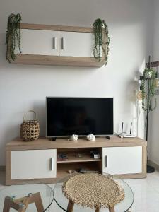 a living room with a television on a wooden entertainment center at Prestige Sunny Terrace Apartment - Torrevieja in Torrevieja