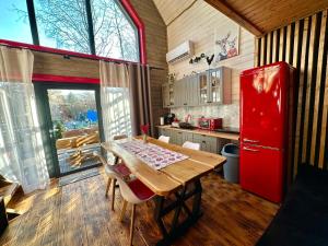 a kitchen with a wooden table and a red refrigerator at Czerwona Stodoła Karkonoska in Podgórzyn