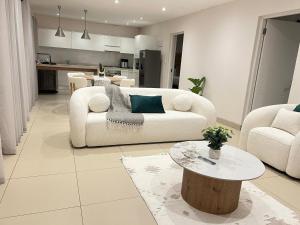 a living room with a white couch and a table at Valley Croft Farm in Hekpoort