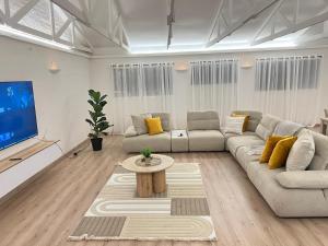 a living room with a couch and a tv at Valley Croft Farm in Hekpoort