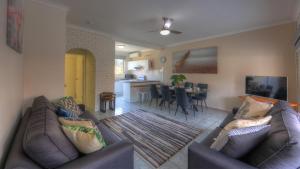 a living room with two couches and a dining room at Yamba Motor Inn in Yamba