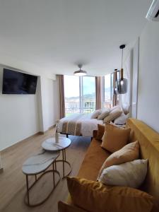 a living room with two beds and a couch at Blue Piscis Studio - Piscina in Benalmádena