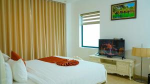 a hotel room with a bed and a television at Lan Chau Luxury Hotel in Cửa Lô