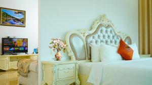 a bedroom with a white bed and a tv at Lan Chau Luxury Hotel in Cửa Lô