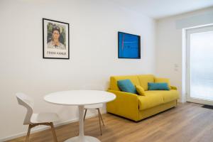 a living room with a yellow couch and a table at Ospitalità Il Prato in Iesi