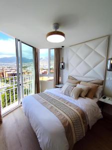 a bedroom with a large bed with a large window at Blue Piscis Studio - Piscina in Benalmádena +5 photos