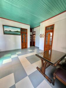 a room with a table and a green ceiling at Hạnh Homestay in Thôn Trị Thủy